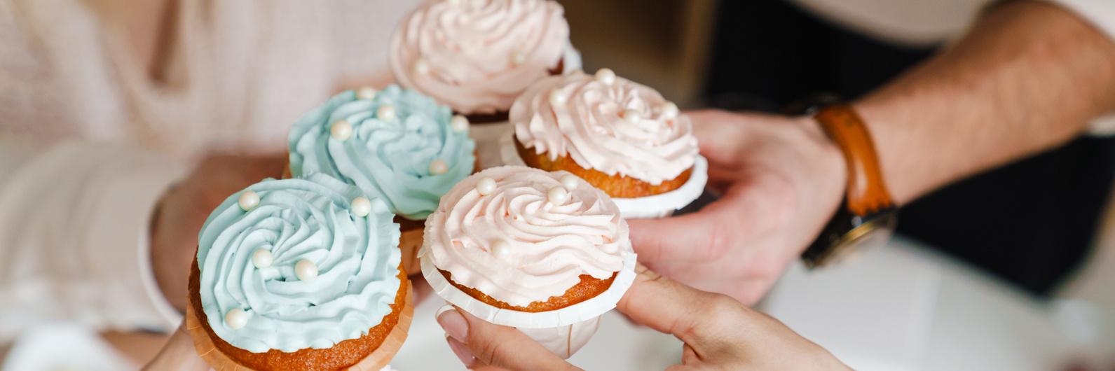 White Friends Holding Muffins during Gender Reveal Party Indoors